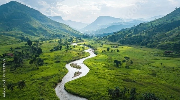Obraz Serene mountain valley river winding through lush green fields