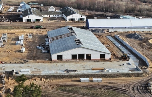 Obraz A building site where an agricultural farm is being erected. A construction site outside the city. Innovative construction in the agro-industry.