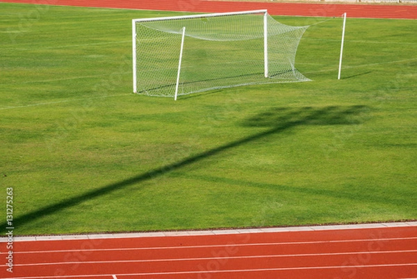 Fototapeta Soccer goal with red running track in stadium