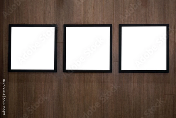 Fototapeta Three empty white isolated frame on the wood wall