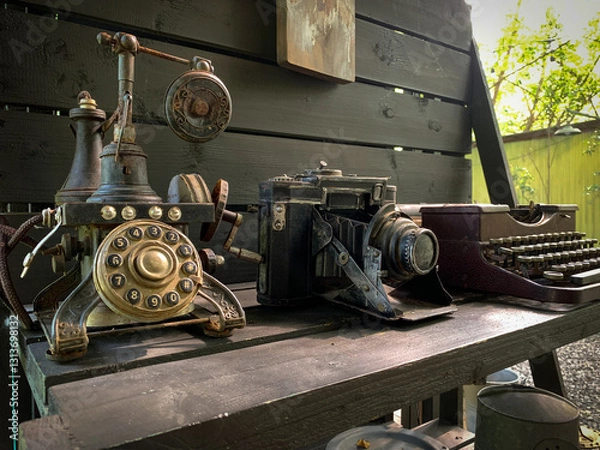 Fototapeta Telephone, camera and old rusty antique typewriter on the table