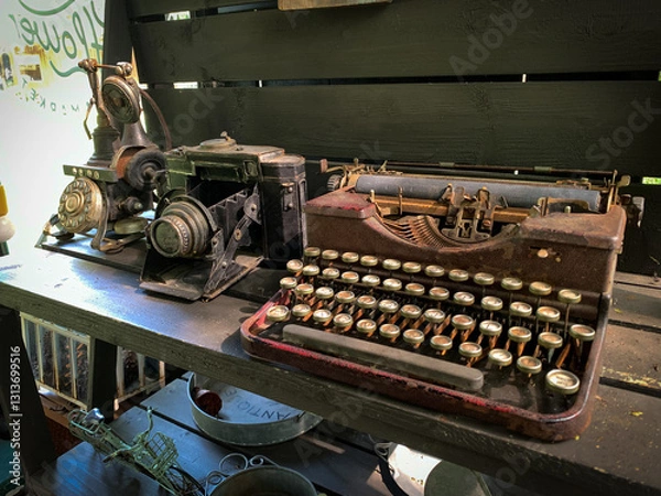 Fototapeta Telephone, camera and old rusty antique typewriter on the table