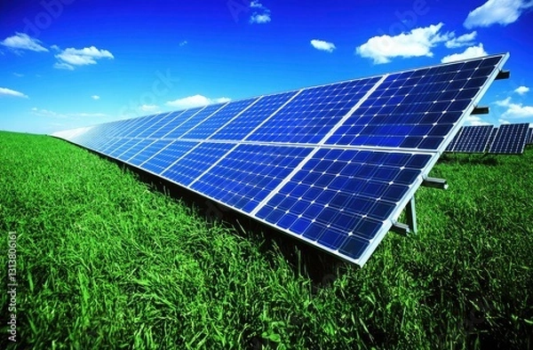 Obraz Solar panels on a grassy field under a vibrant blue sky
