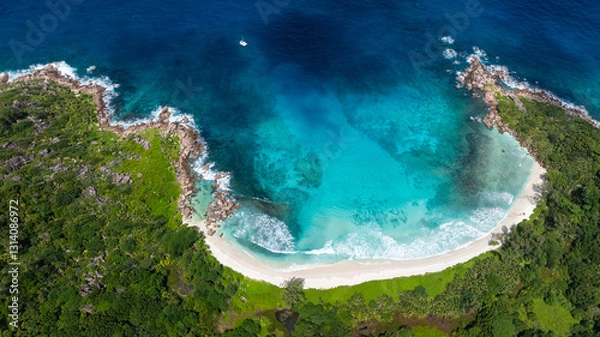 Fototapeta Turquoise bay surrounded by rocky cliffs and dense green vegetation with a serene beach. Anse Cocos beach. La Digue, Seychelles.