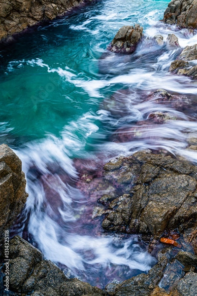 Fototapeta Water flowing over rocks on the coastline