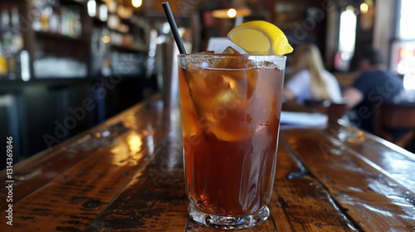 Fototapeta Chilled Iced Tea with Lemon Garnish in a Rustic Bar Setting with Warm Ambience