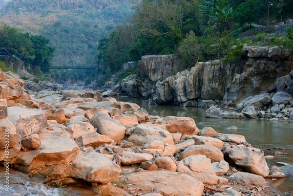 Fototapeta Tlawng River of Mizoram with suspended bridge and rocks all around