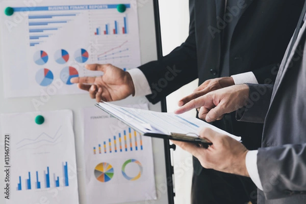 Obraz Businessman making a presentation at work in front of colleague. Businessman coach mentor explain graph chart on flipchart corporate group workshop training in meeting room.