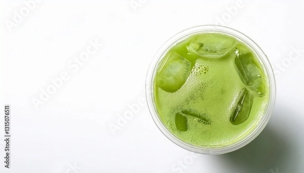 Fototapeta a refreshing iced matcha drink in a transparent cup, top view. The drink is a vibrant green color, with ice cubes