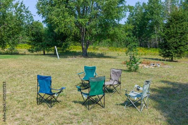 Obraz Five folding lawn chairs sitting out in a rural Michigan lawn.