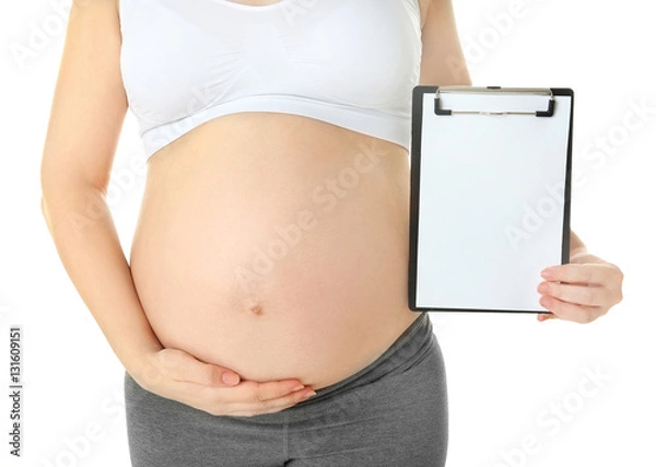 Fototapeta Closeup of pregnant woman with clipboard isolated on white