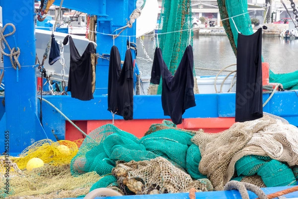 Obraz Fisherman clothes drying on a fishing boat with nets