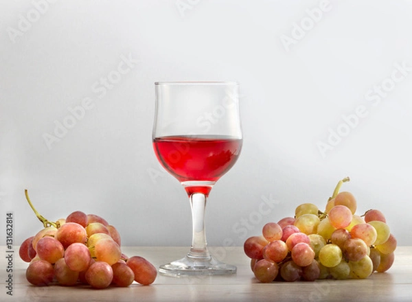 Fototapeta Виноградное вино в стеклянном бокале и грозди винограда .\Полезное натуральное виноградное вино.