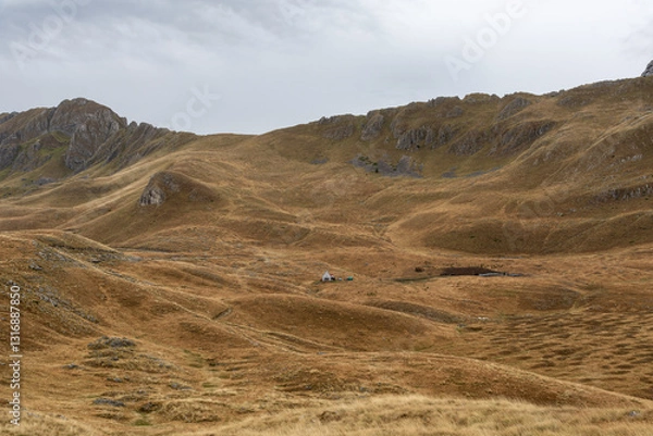 Fototapeta Zabljak, Montenegro - 19 August 2024 Remote house surrounded by hills