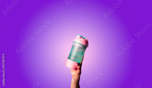 Obraz Hand holds a sports shaker. Female hand holds a protein shaker, copy space.