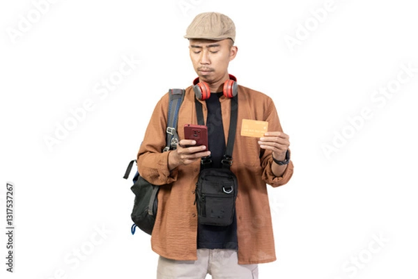 Fototapeta Young Indonesian male traveler traveling with credit card, convenience of cashless transaction, travel concept, isolated on white background.