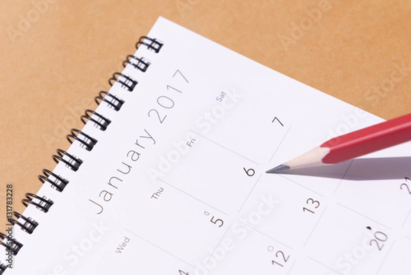 Fototapeta The 2017 new year calendar  on the brown background with the red pencil