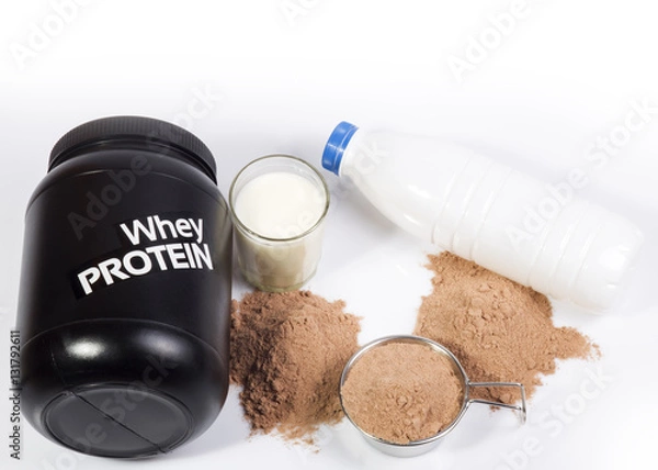 Obraz Jar with whey protein. Big stainless steel Scoop with chocolate protein, two protein heaps, glass with fat free milk and white bottle with milk. Diet set for fitness and bodybuilding for muscle grow.