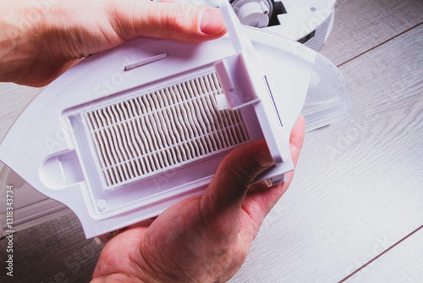 Obraz Maintenance of the robot vacuum cleaner. Replacement of brushes and filter. The master repairs the vacuum cleaner. Gloves and a master's tool.