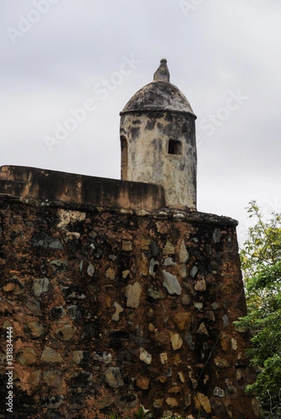 Obraz Part of an old fort, with a side of a watchtower over a wall made of stone.