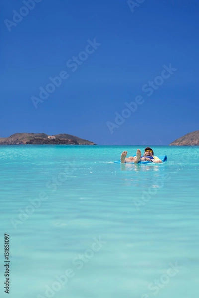 Fototapeta Total relaxation as a man drifts off on the calm waters of tropical Magens Bay, St. Thomas