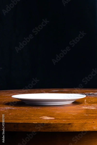 Fototapeta empty white plate on an old table side view