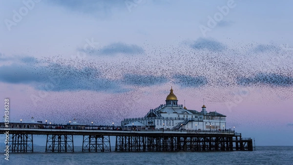 Obraz Amazing image of starling murmuration in flight over Victorian pier during pastel colour Winter sunset evening