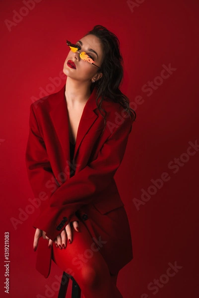 Obraz Young Woman In Red Suit With Red Lips And Sunglasses Posing On The Red Background
