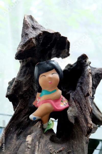 Fototapeta ceramic girl on a log