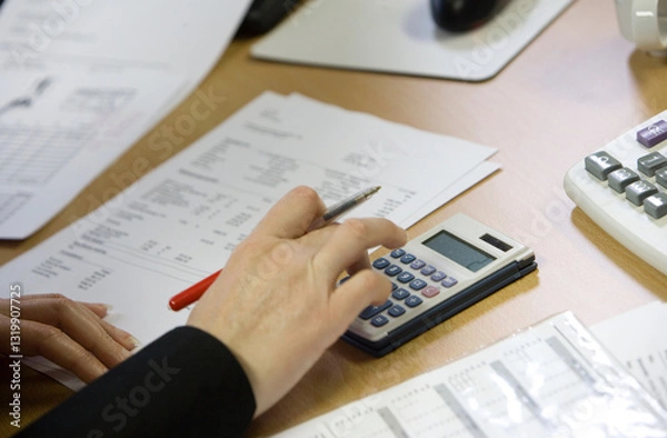 Obraz At the office. Administration office. Hand with keyboard of a computer. Counting machine.