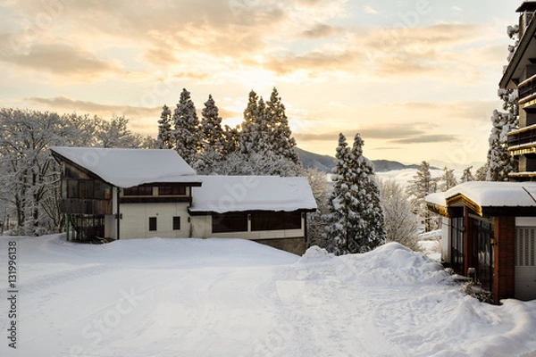 Obraz Myoko ski lodges during early morning sunrise.  Low cloud cover hovers over the lower parts of town. There are no people to be seen at this time of day.