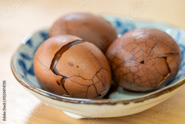 Fototapeta Cracked Eggs Resting in a Beautifully Decorative Ceramic Bowl, Perfect for Any Dining Table