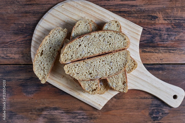 Fototapeta cross section of  homemade wholegrain bread slices on cutting board