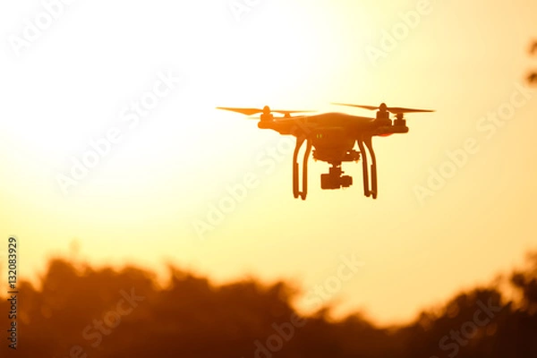 Fototapeta Sylwetka drona latające w świetle słońca piękne