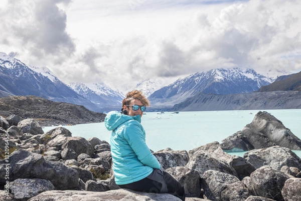 Fototapeta Female tourist enjoying breathtaking view of tasman lake and southern alps in new zealand