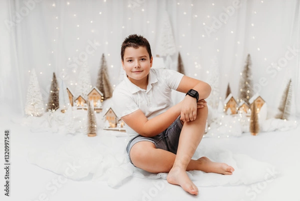 Obraz Studio portrait of a 10-year-old boy in a festive Christmas setting.