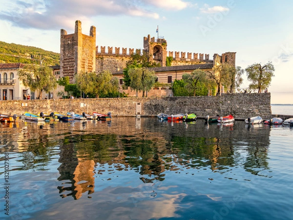 Obraz The Scaligero Castle by the small port of Torri del Benaco, Garda lake, Italy. An impressive medieval structure with walls and towers, reflecting its historical significance and architectural style.