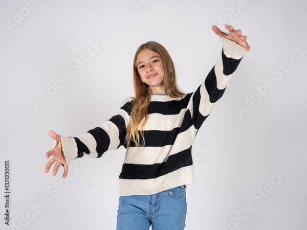 Fototapeta beautiful teen girl wearing striped sweater looking at the camera smiling with open arms for hug. Cheerful expression embracing happiness.