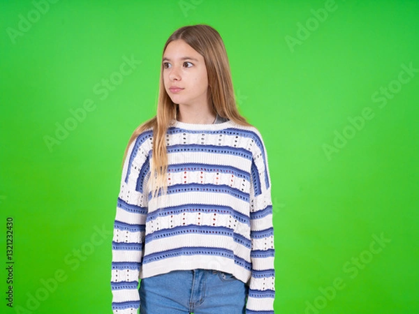 Fototapeta beautiful teen girl wearing striped sweater stares aside with wondered expression has speechless expression. Embarrassed model looks in surprise