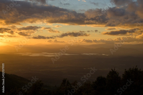 Fototapeta Autumn sunset light with clouds in blue sky with mountain landscape between the trees in horizontal HDR