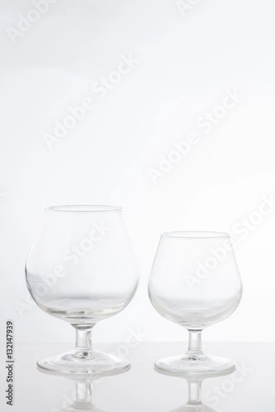 Fototapeta Empty clear short stem wine glasses on a white background
