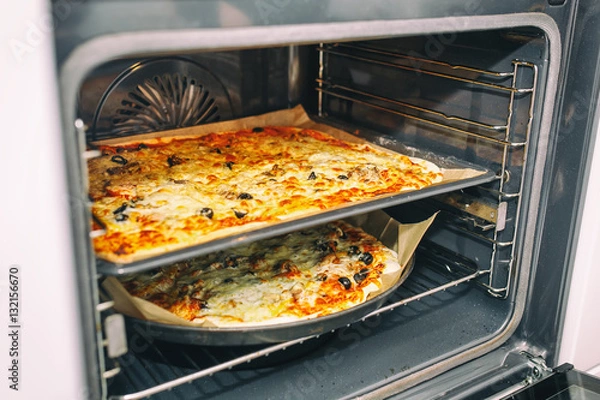 Fototapeta Homemade pizza coming out of oven. Healthy food concept. Selective focus.