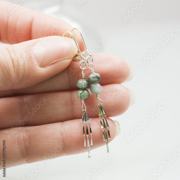 Obraz Silver earrings and necklace with emerald gemstones on white background