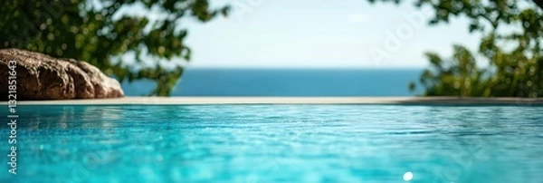Fototapeta A tranquil swimming pool overlooking a serene ocean, inviting relaxation and leisure, perfectly blending water elements with natural coastal beauty under bright sunlight.