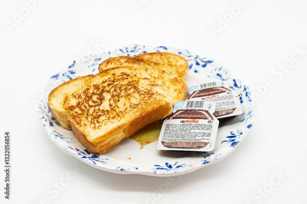 Fototapeta A plate with two pieces of toast and a jar of Nutella