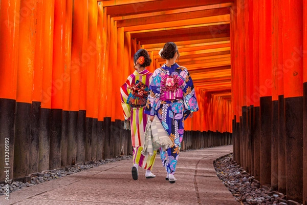 Fototapeta Women in traditional japanese kimonos walking at Fushimi Inari Shrine in Kyoto, Japan