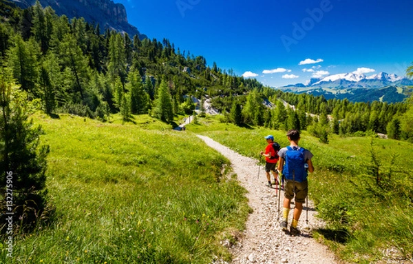 Obraz Pair of excursionist walking on mountainous trail. Summer Trekking