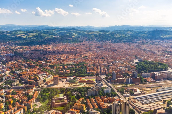 Fototapeta Aerial view of Bologna city in Italy with Asinelli Towers, San Luca Basilica church on Bologna hill and train station.