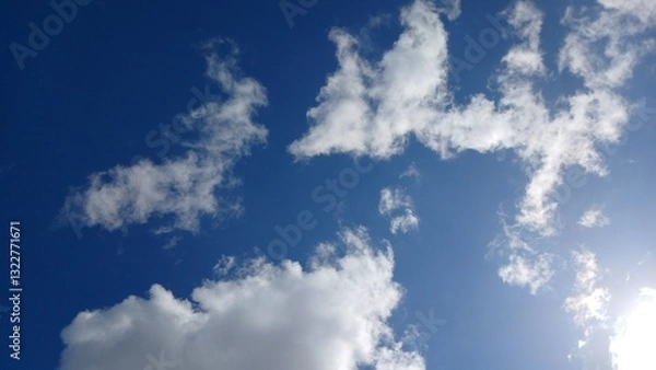 Obraz A clear blue sky background with scattered clouds 
