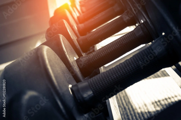 Fototapeta Rows of dumbbells in the gym with hign contrast and monochrome c